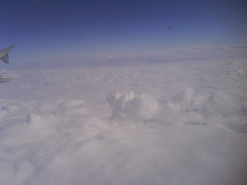 Airplane Wing Above Clouds — White, Serene, Photograph