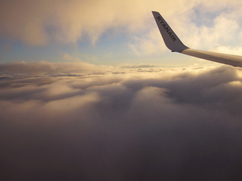 Airplane Wing Above Clouds — White, Serene, Sunset