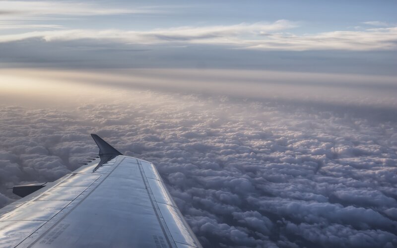 Airplane Wing Above Clouds — White