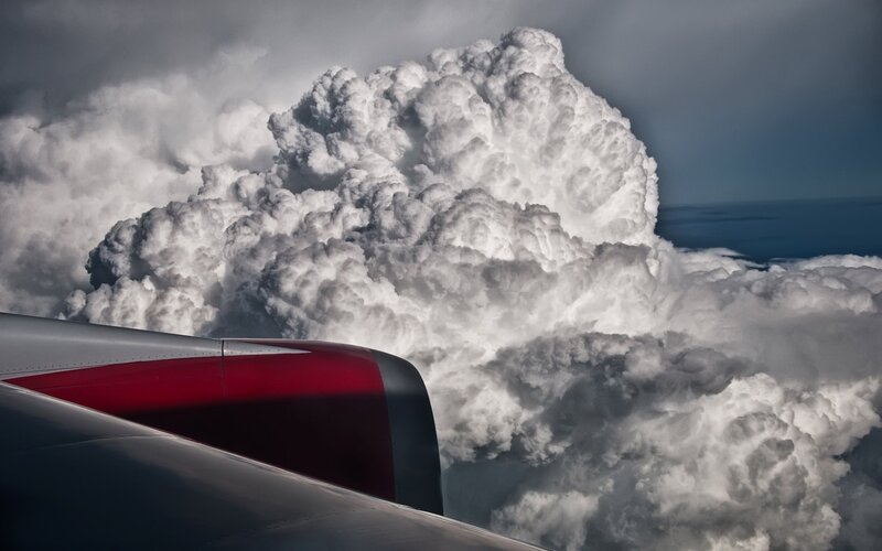 Airplane wing near storm cloud