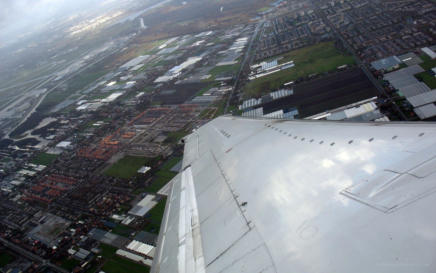 airplane wing over city