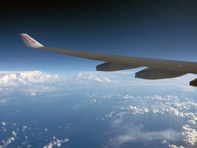 Airplane wing over clouds