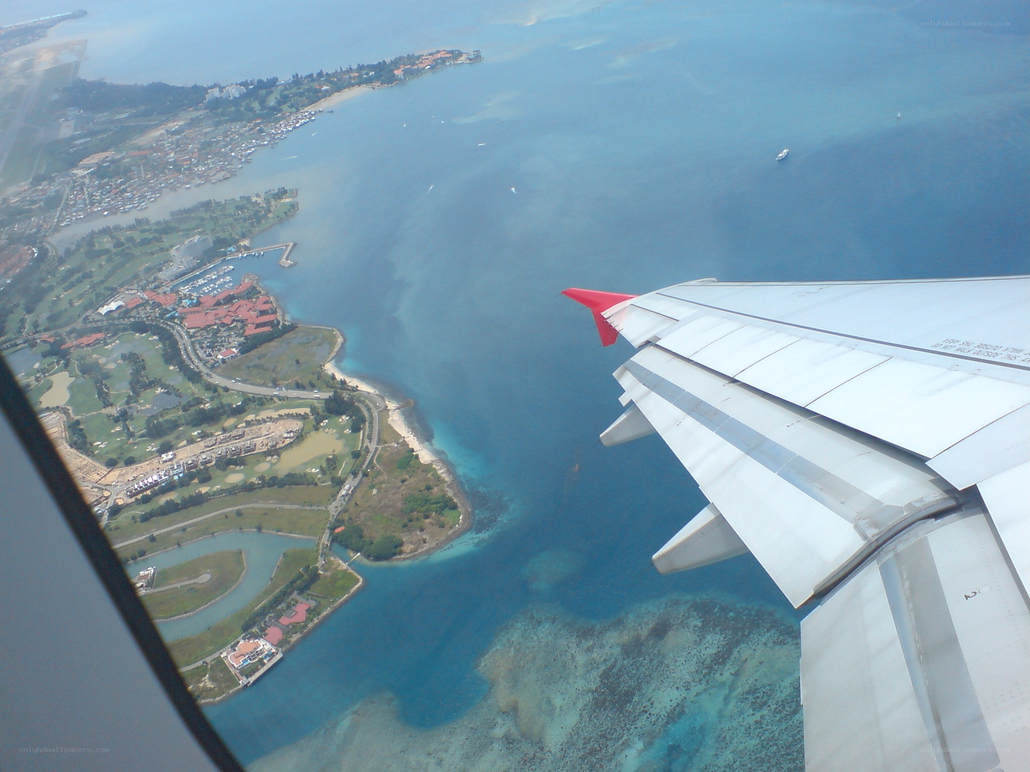 airplane wing over coastal area
