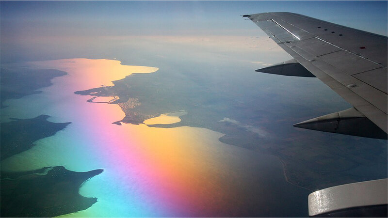 airplane wing over coastal landscape