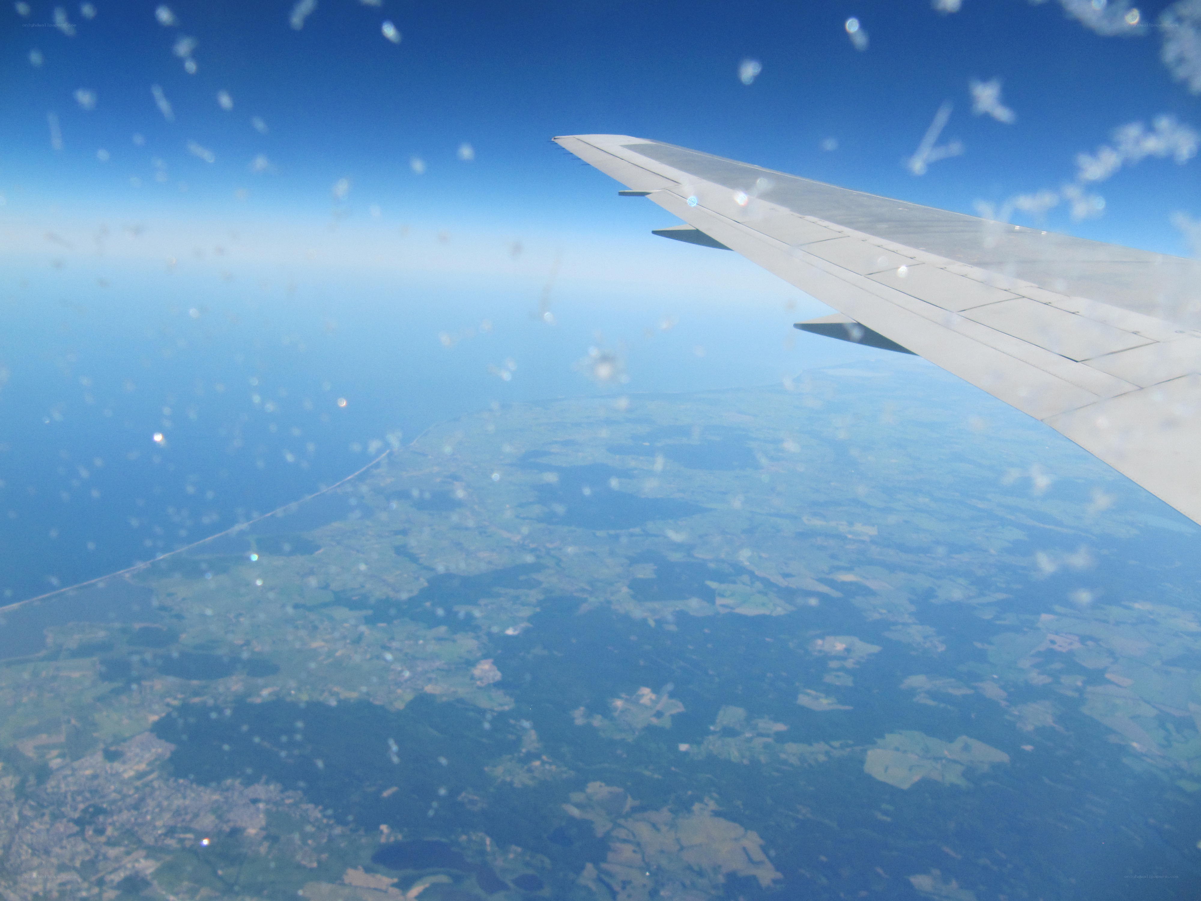 airplane wing over coastal landscape