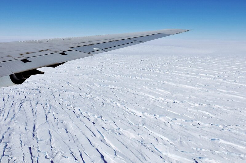 Airplane wing over ice field
