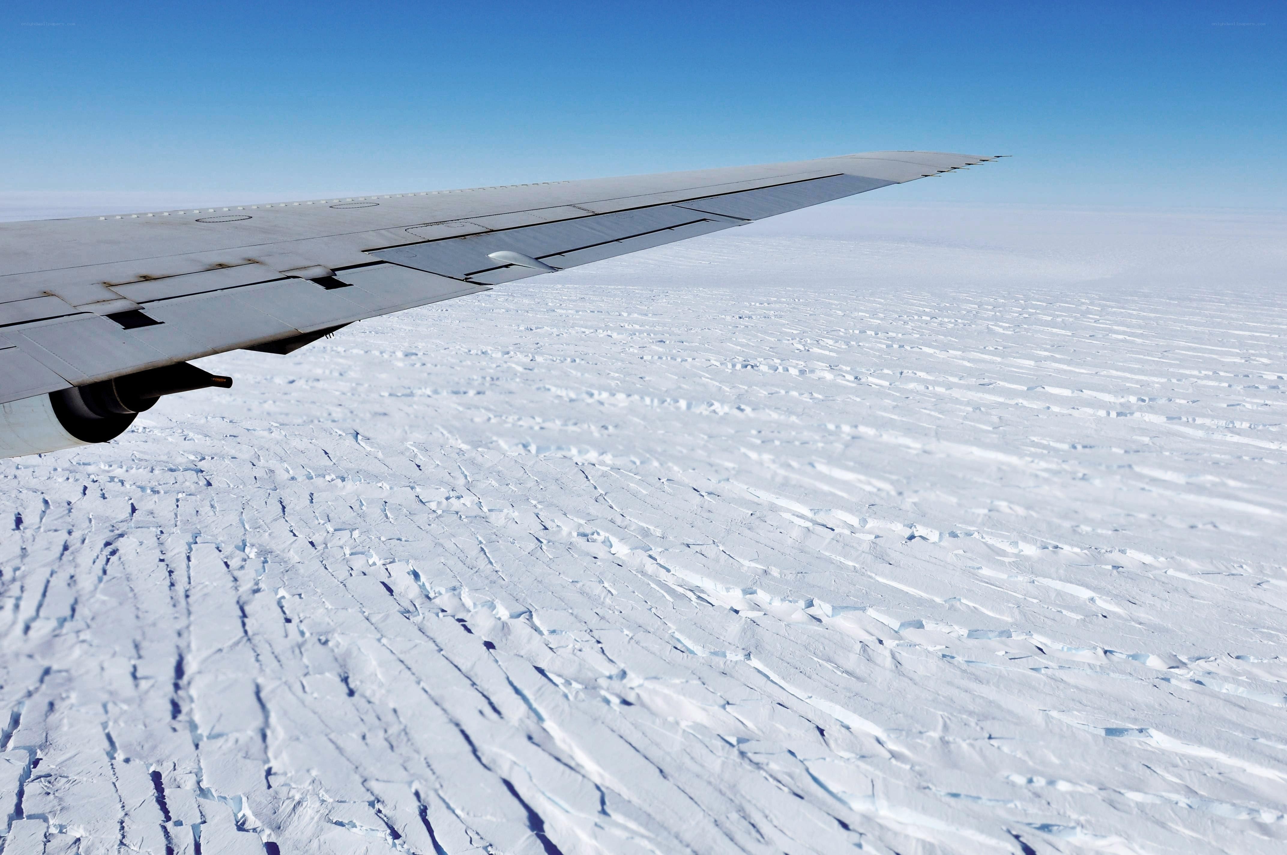 Airplane wing over ice field
