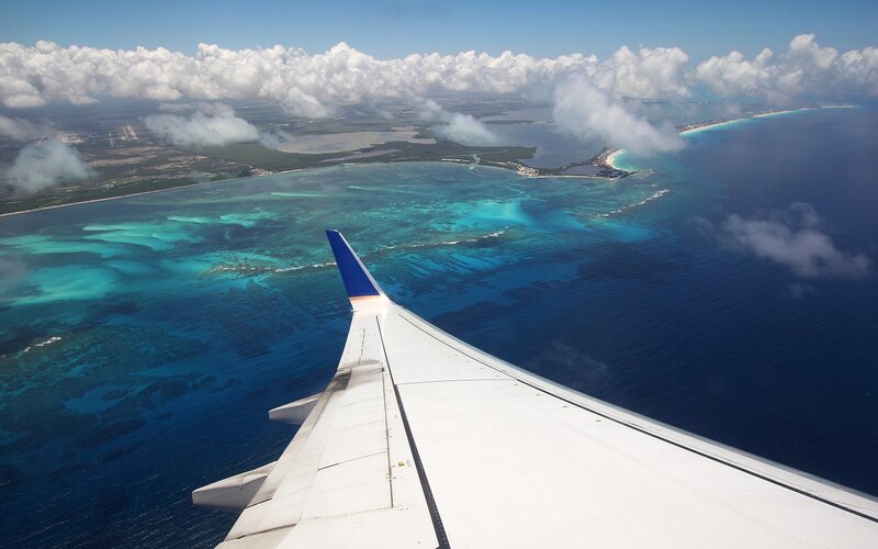 Airplane Wing over Island — Blue