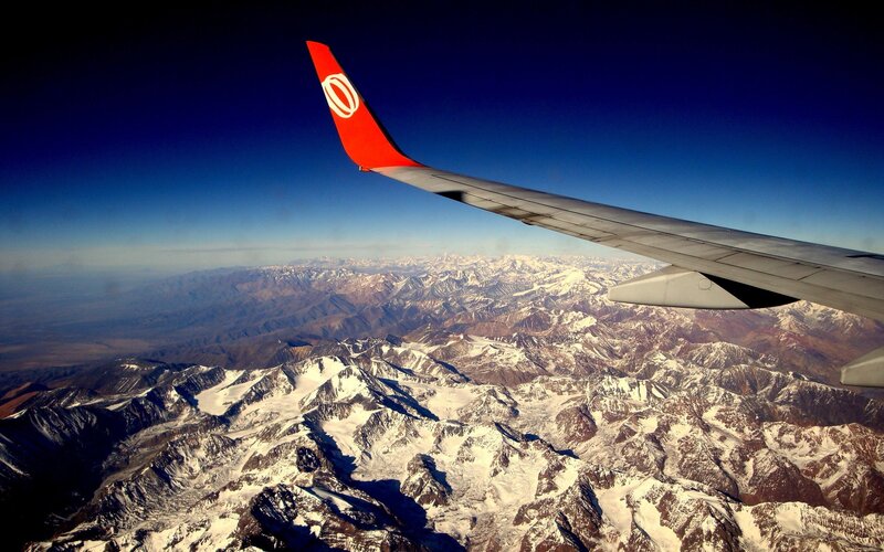 Airplane Wing over Mountains — Blue, Dramatic