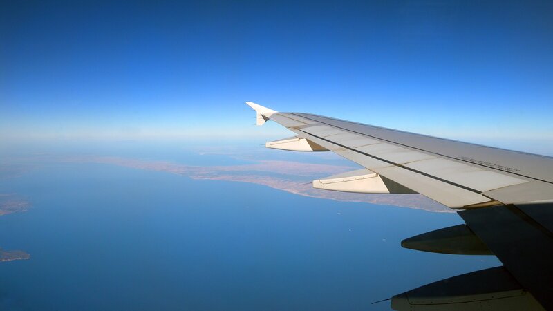 Airplane wing over sea