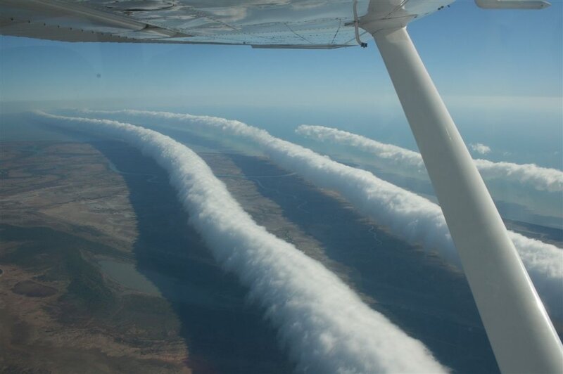 airplane wing with cloud trails