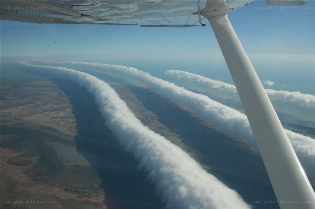 airplane wing with cloud trails