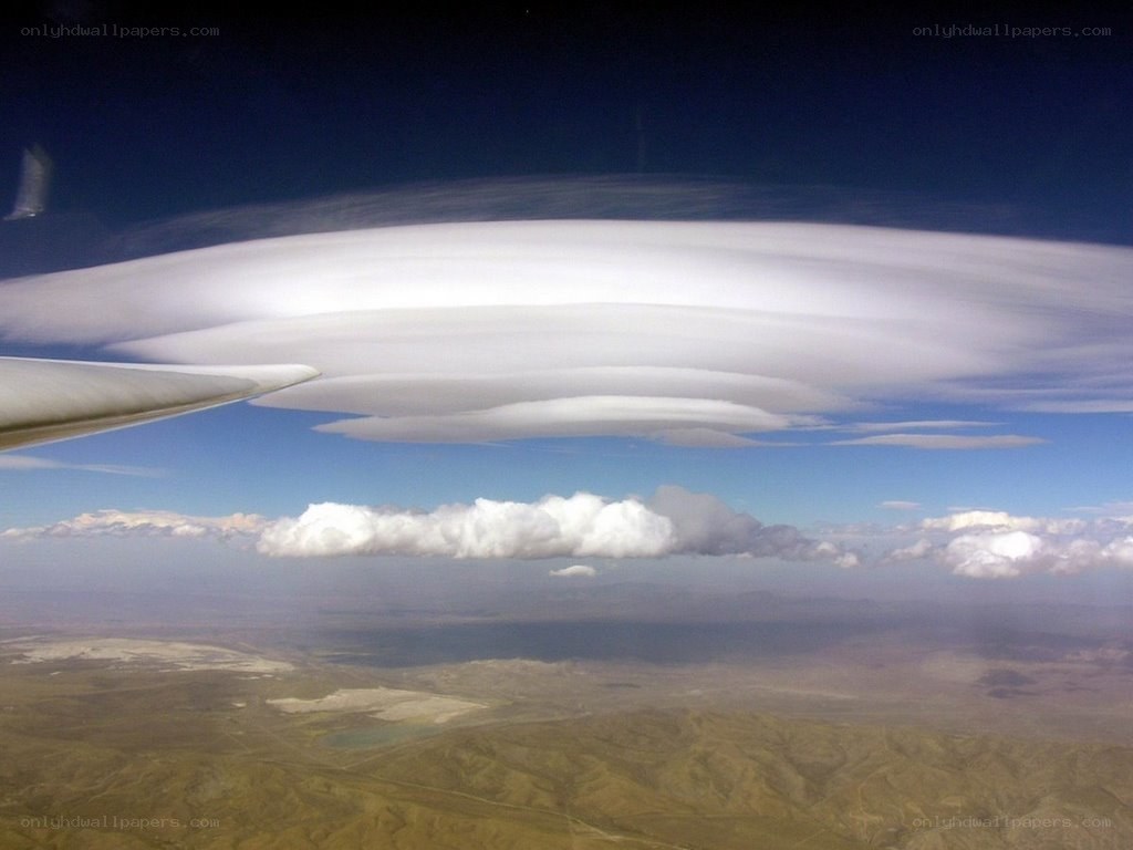 airplane wing with lenticular clouds