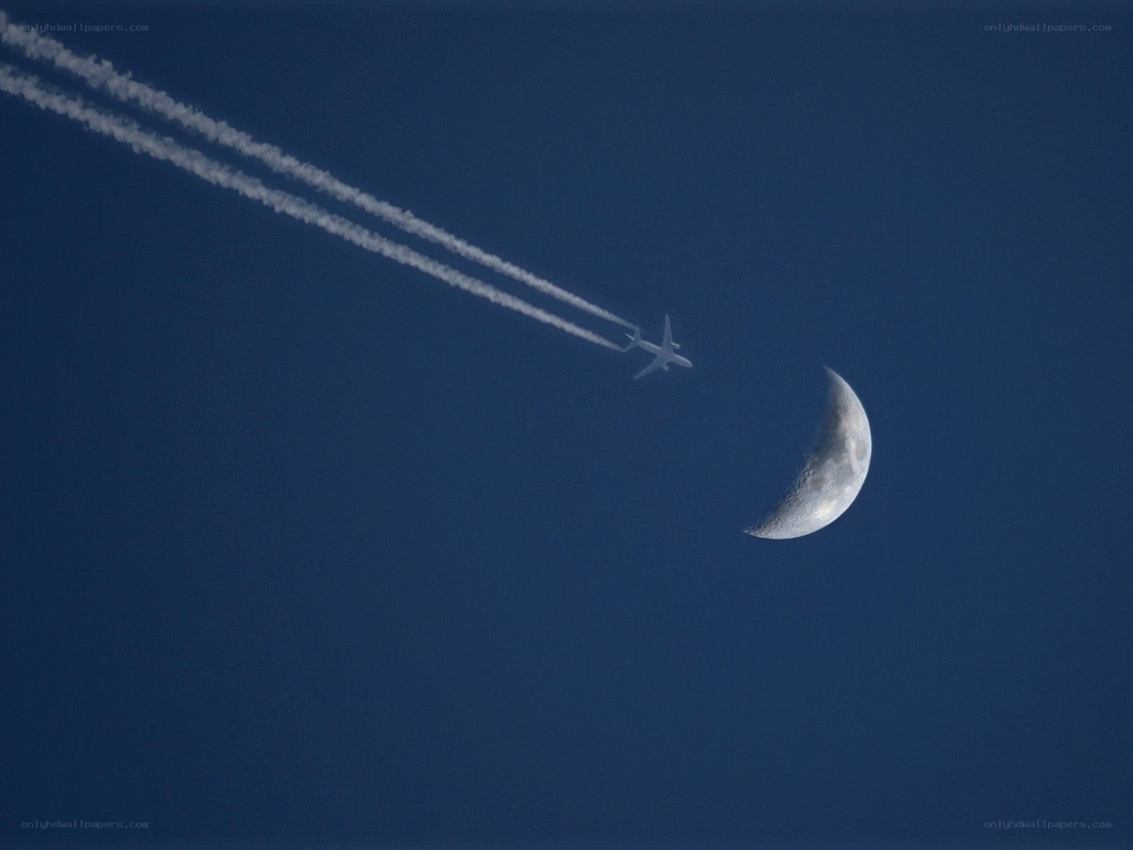 Airplane with contrails near moon