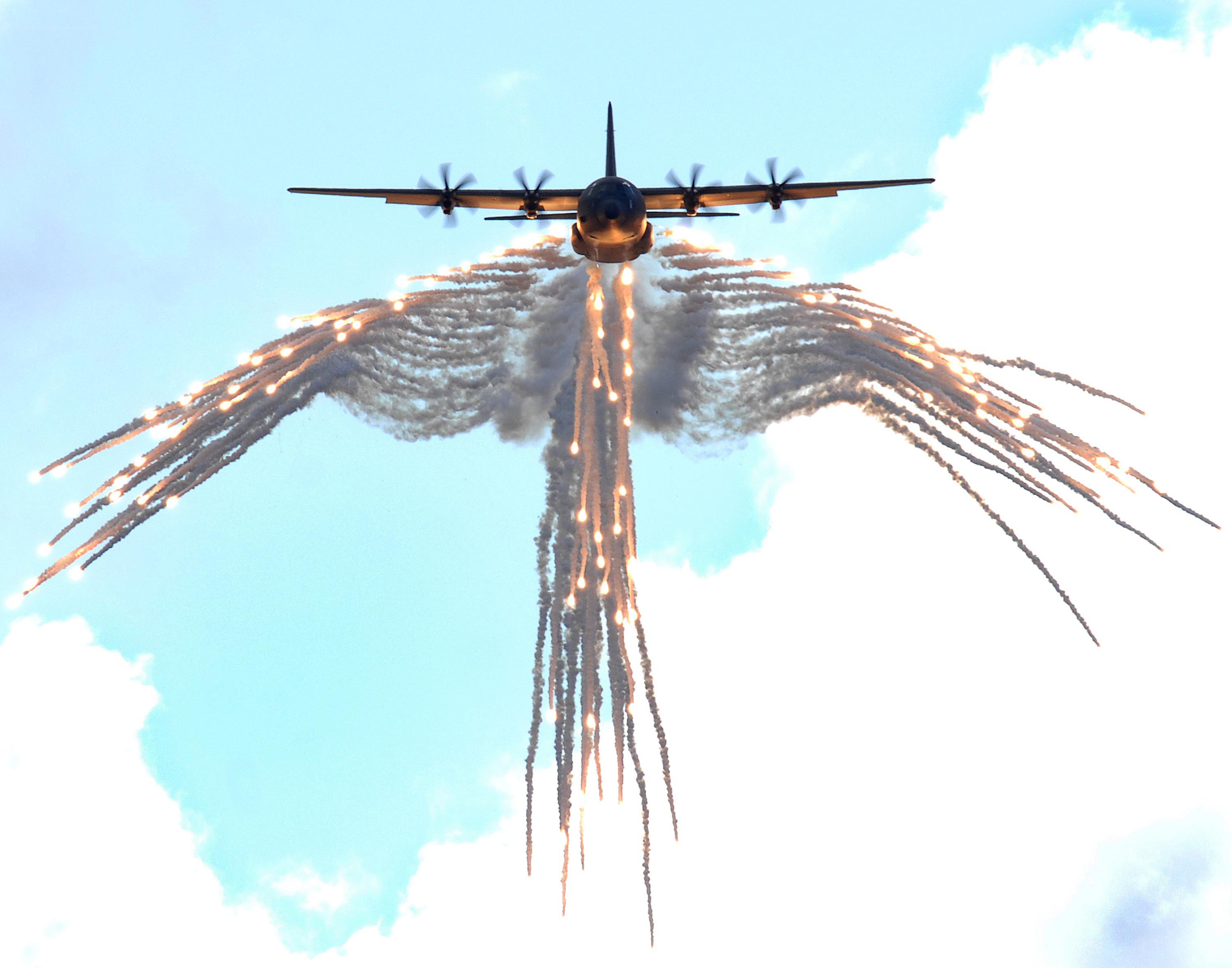 Airplane with flares in sky