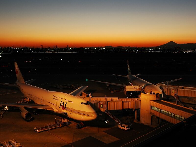 Airplanes at airport during sunset