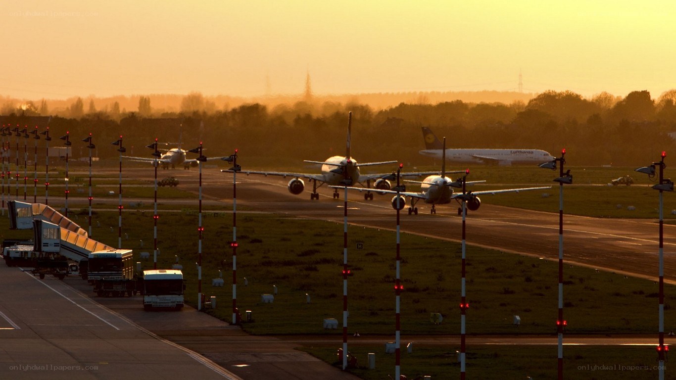 Airplanes on a runway at sunset