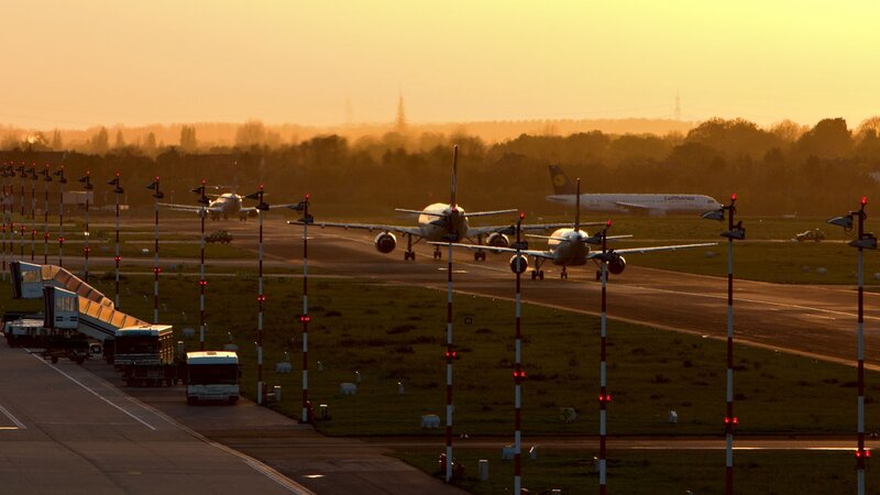 Airplanes on a runway at sunset