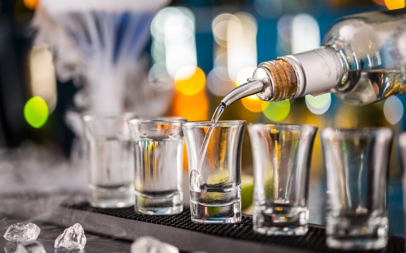 Alcohol Poured into Shot Glasses