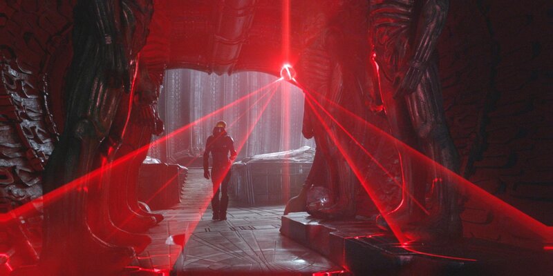 Alien in a red-lit corridor