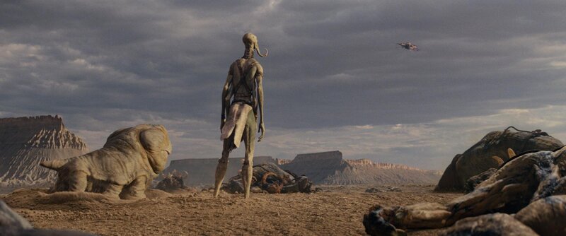 alien stands in desert wasteland