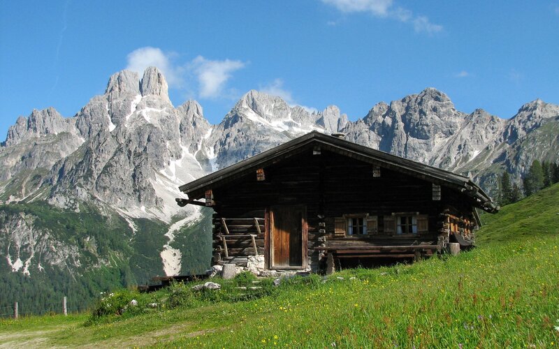 Alpine cabin with mountain backdrop