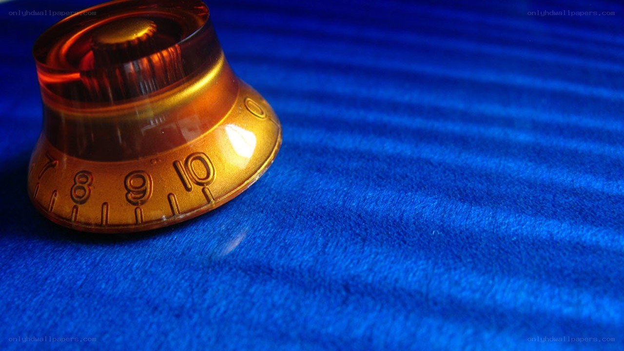 amber guitar knob on blue surface