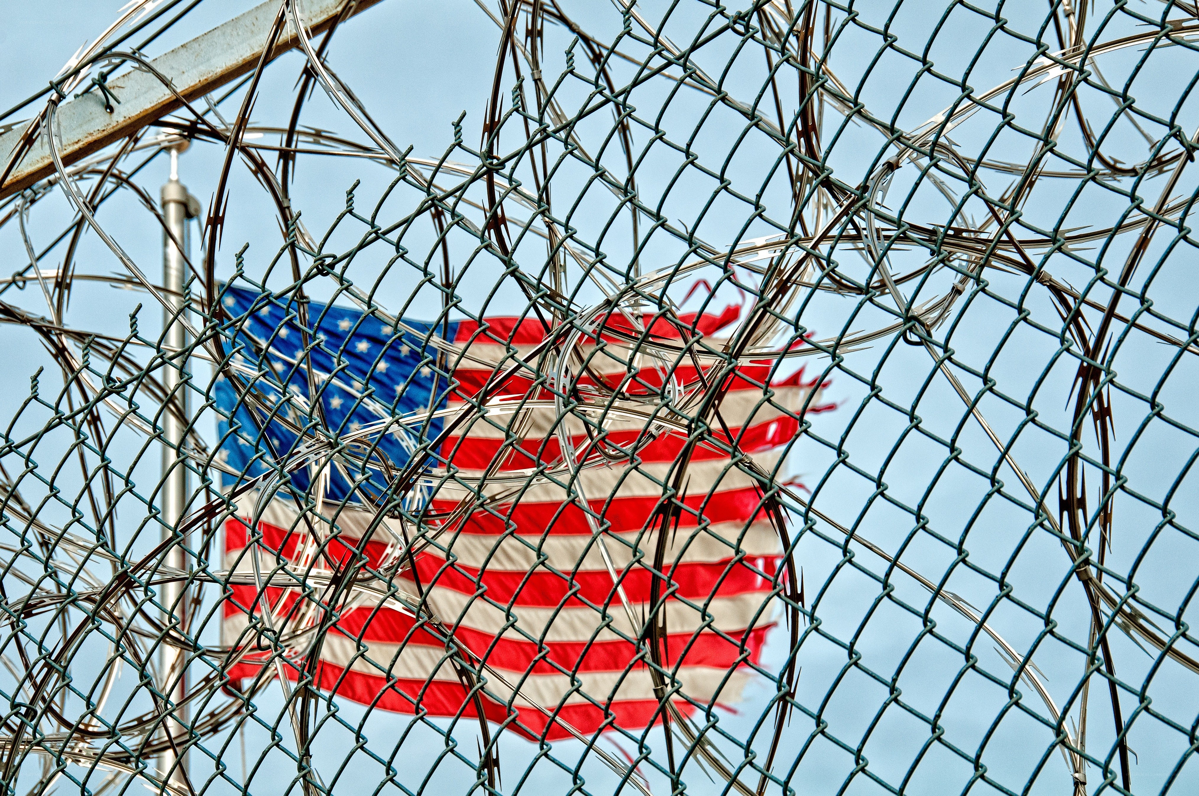 American flag behind barbed wire
