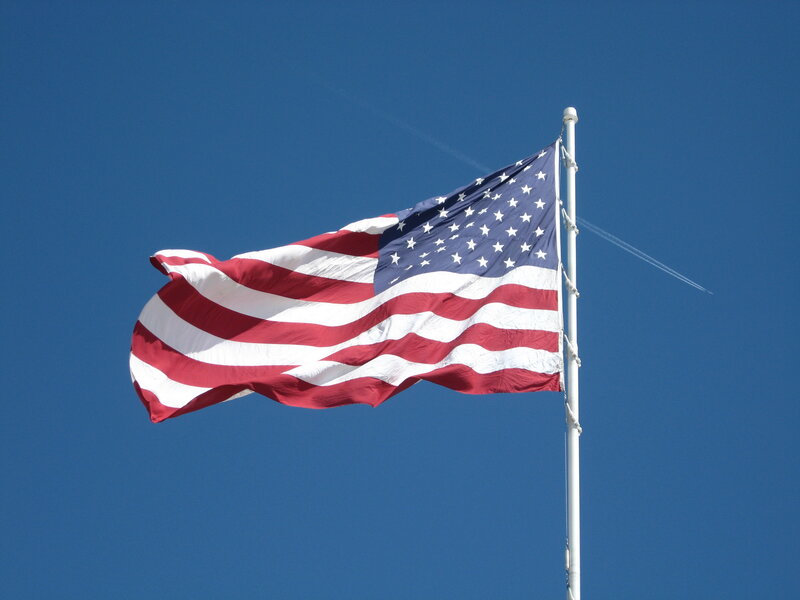 American flag waving in blue sky