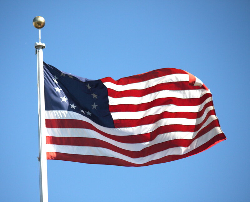 American flag waving in blue sky