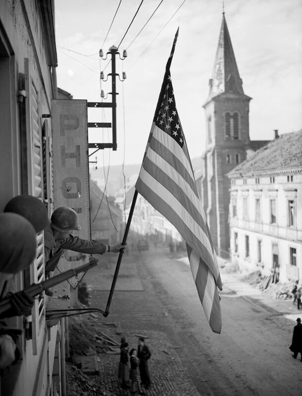 American soldier raising flag in town