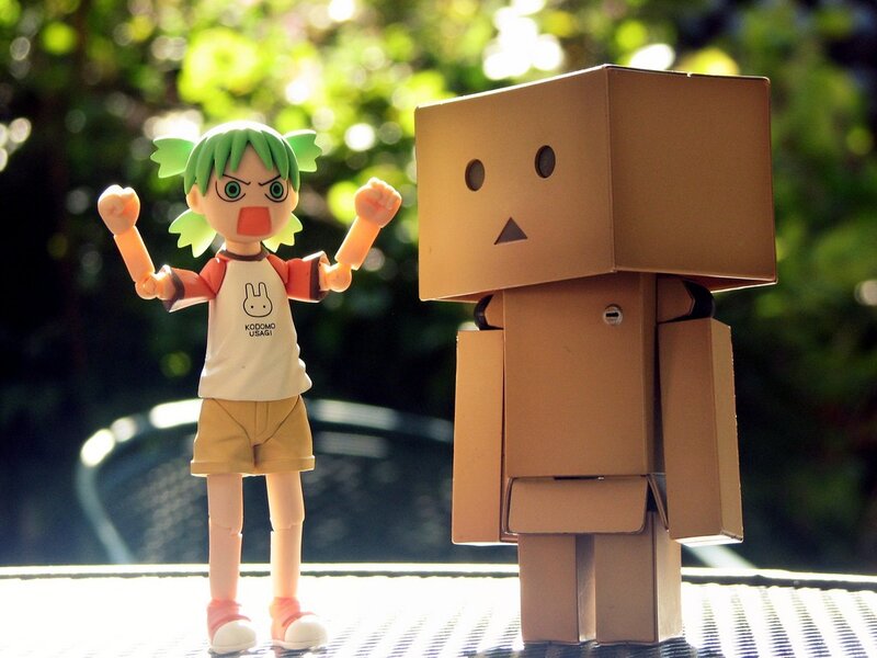 An angry figure stands next to a cardboard robot