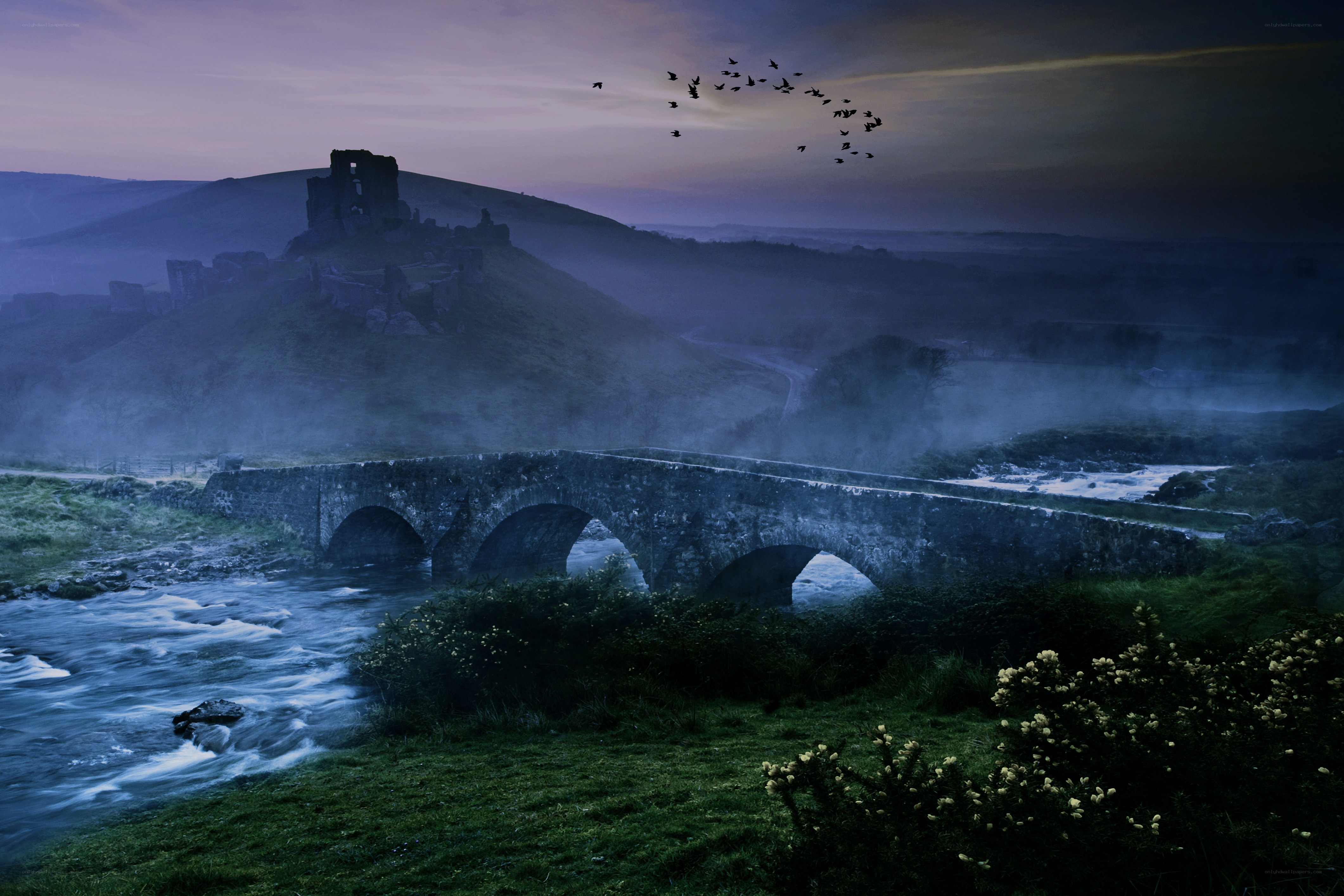 Ancient bridge at dusk with castle ruins