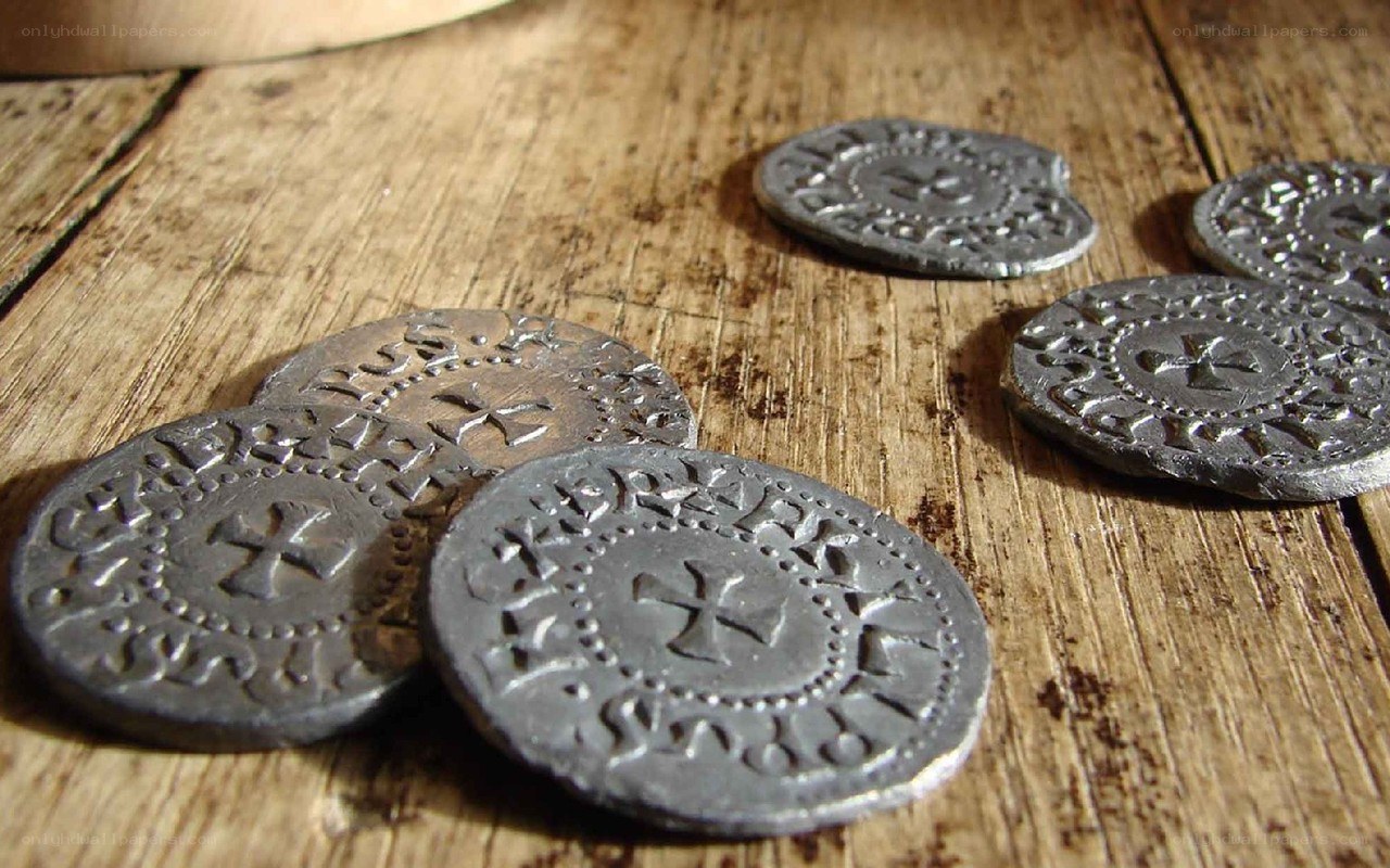 ancient coins on wooden surface