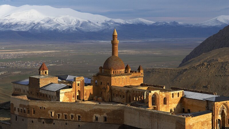 ancient mosque with snow-capped mountains