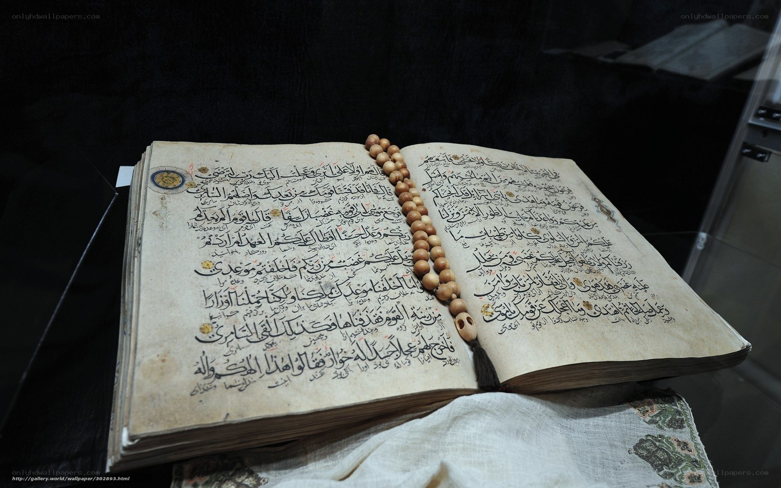 ancient quran with prayer beads