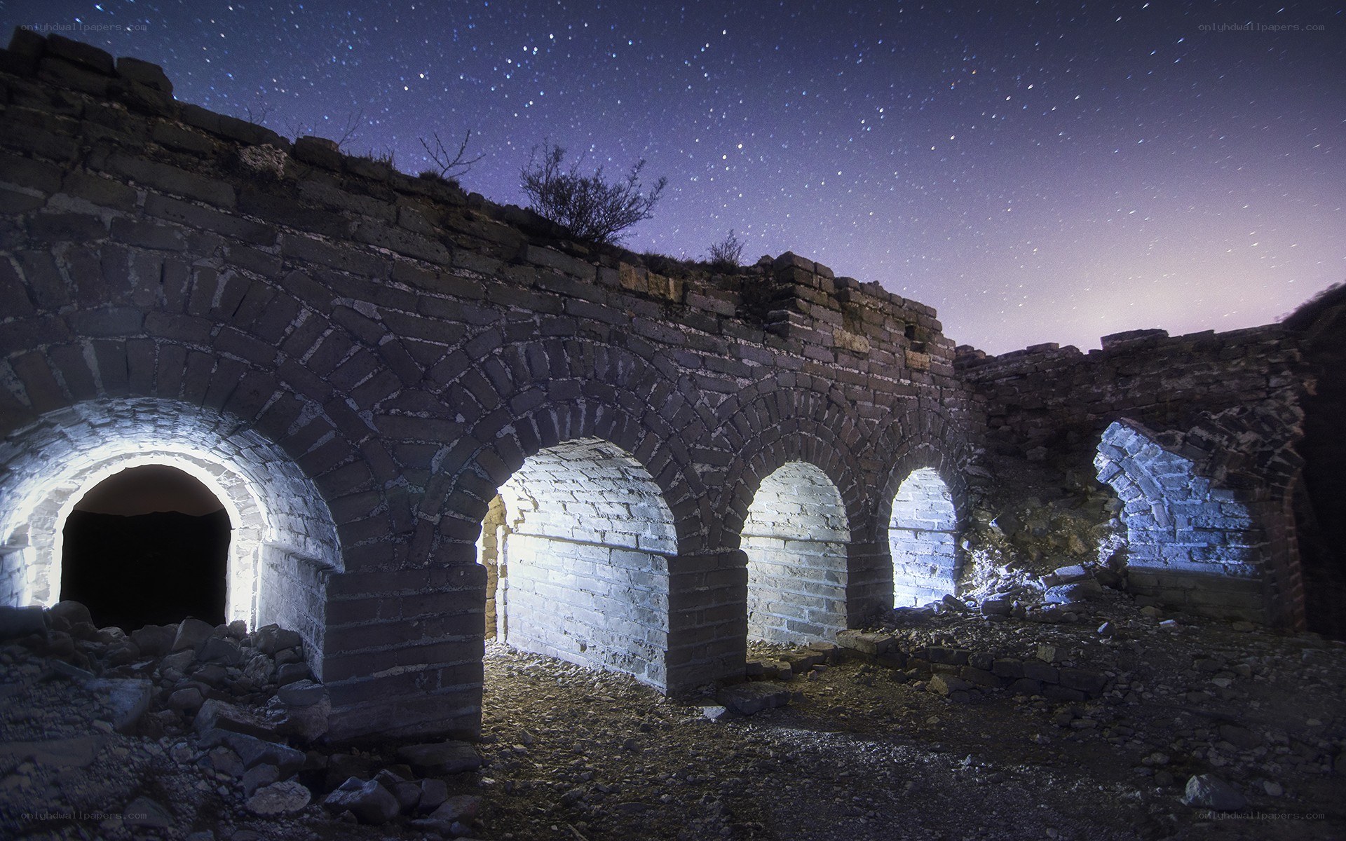 Ancient stone arches under starry sky