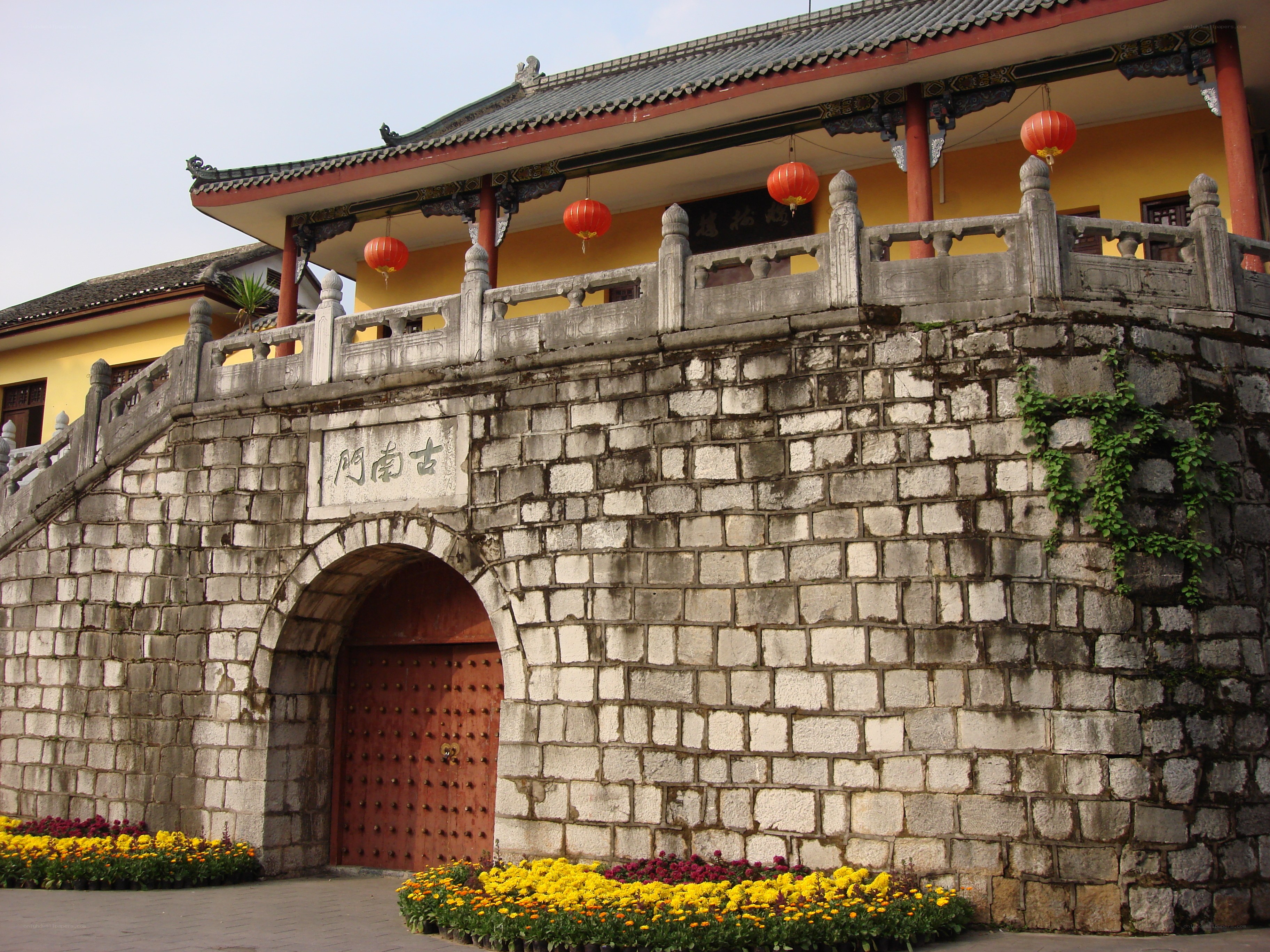 Ancient stone gate with red lanterns