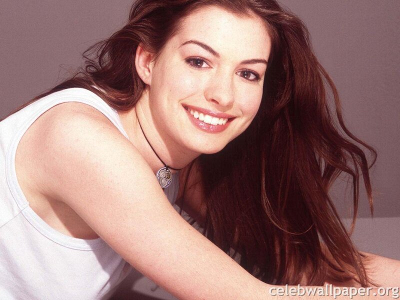 Anne Hathaway smiling in white tank top