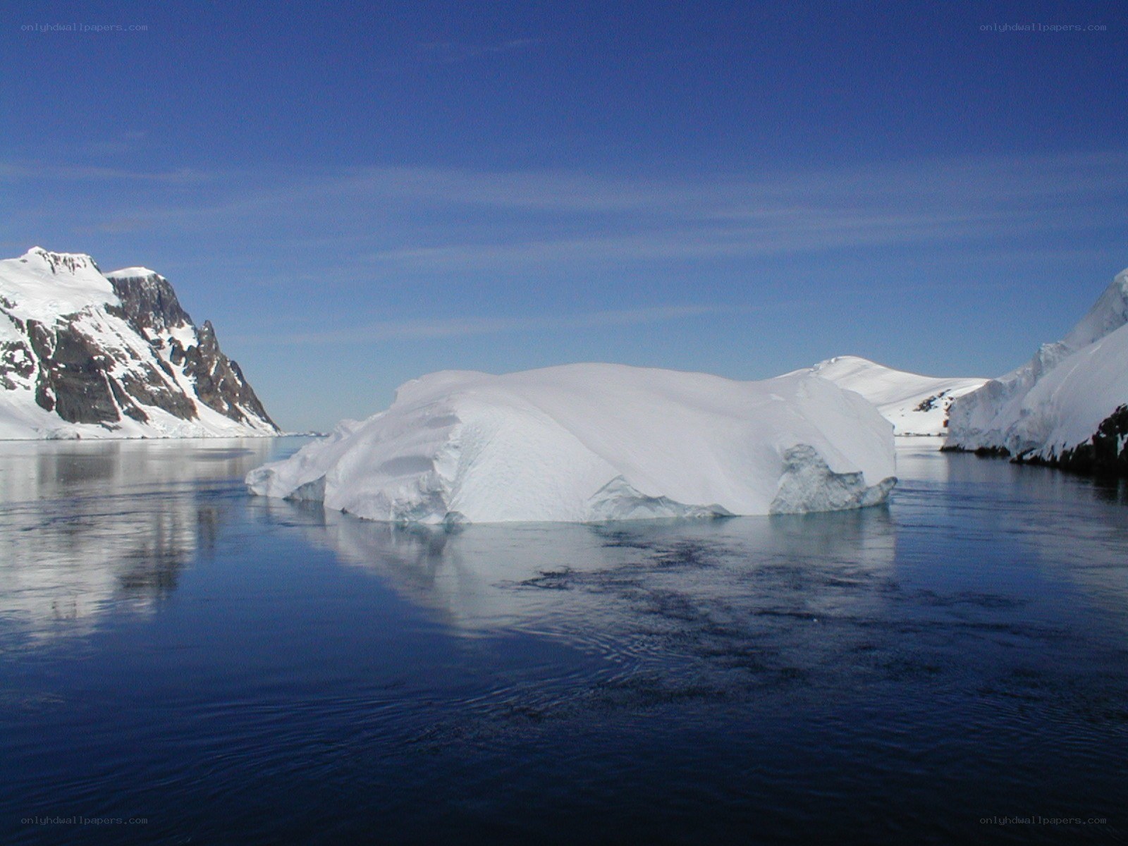 Antarctic iceberg and mountains