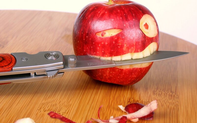 Apple Carved into Face — Red, Playful, Photograph, Knife, Cutting Board, Peel, Brown