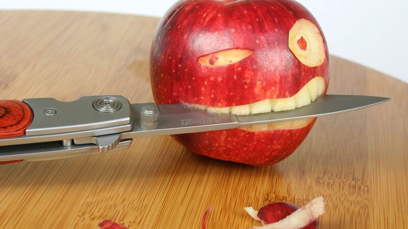 Apple Carved into Face — Red, Playful, Photograph, Knife, Cutting Board, Peel