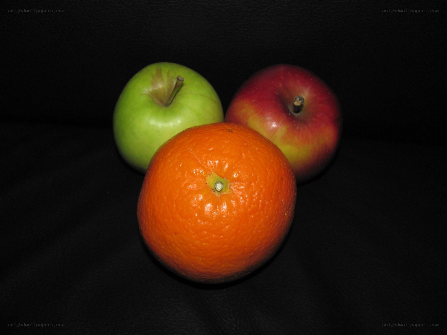 apples and orange on black