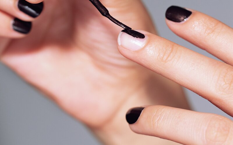 applying black nail polish