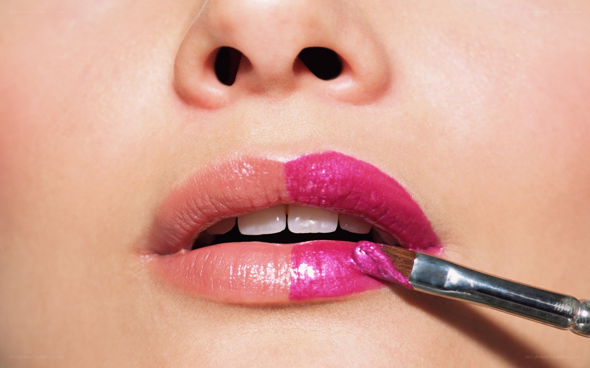applying pink lipstick