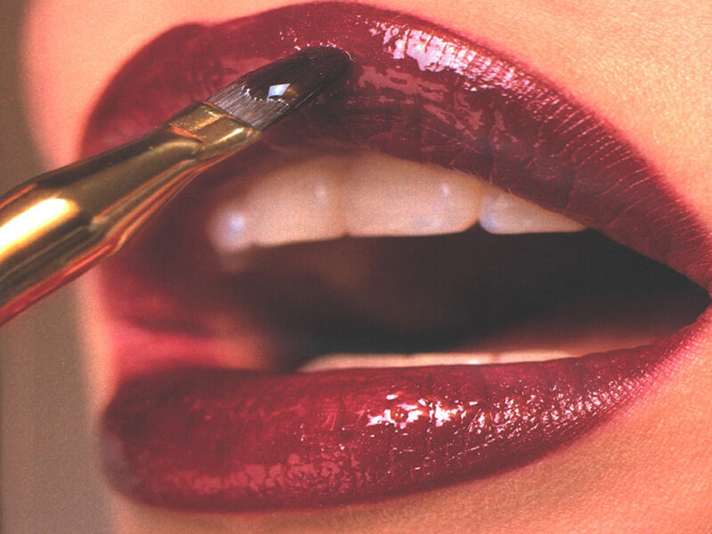 applying red lip gloss