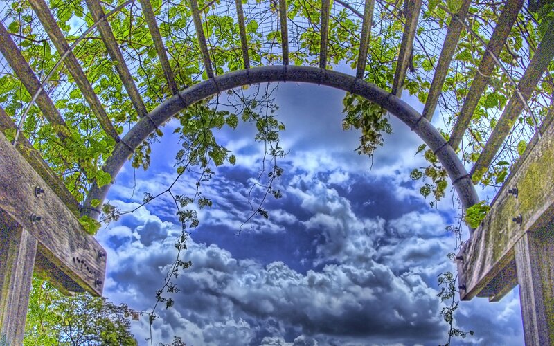 Arched trellis with cloudy sky