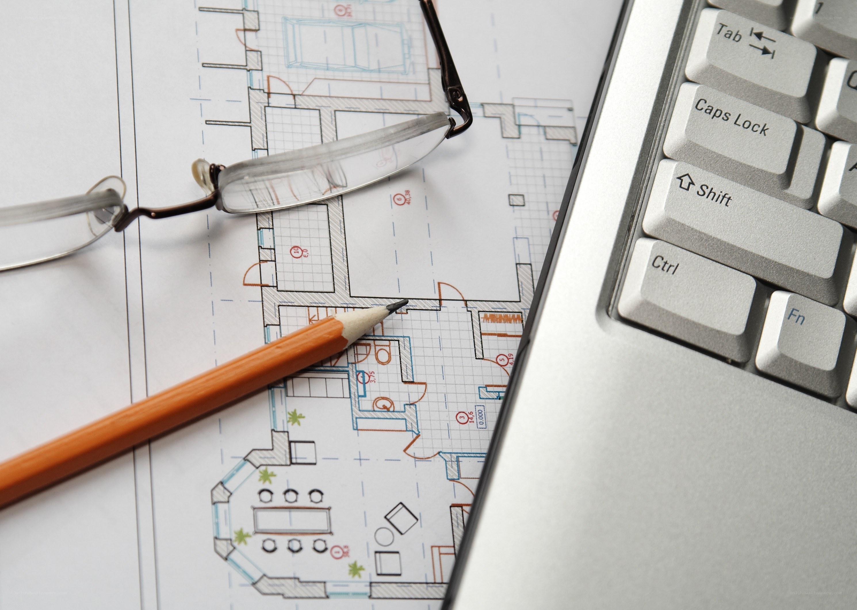 Architectural plans with pencil and laptop
