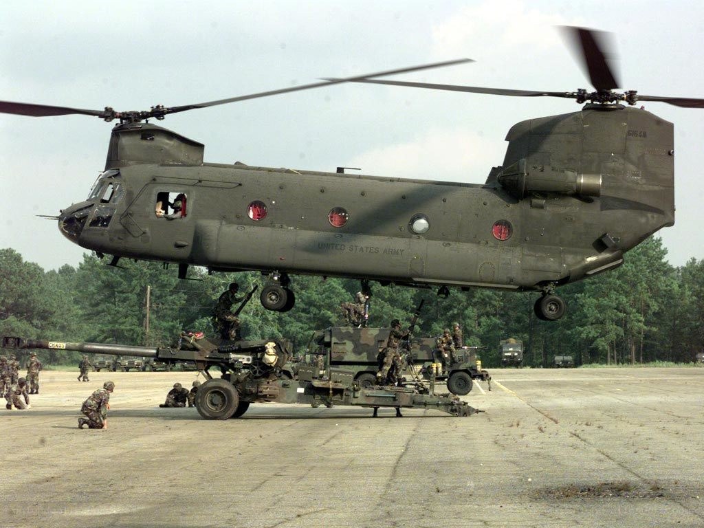 Army helicopter lifting artillery