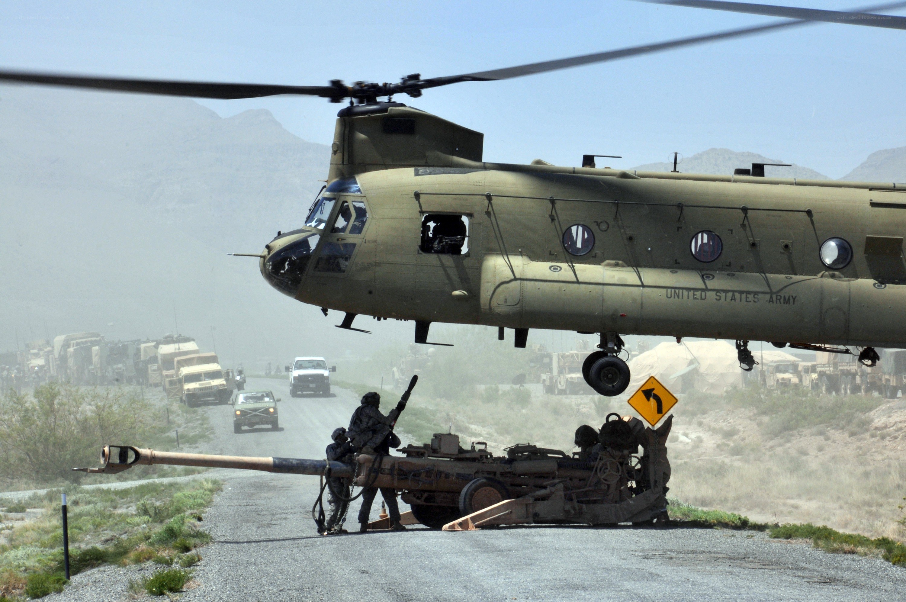 Army helicopter over artillery